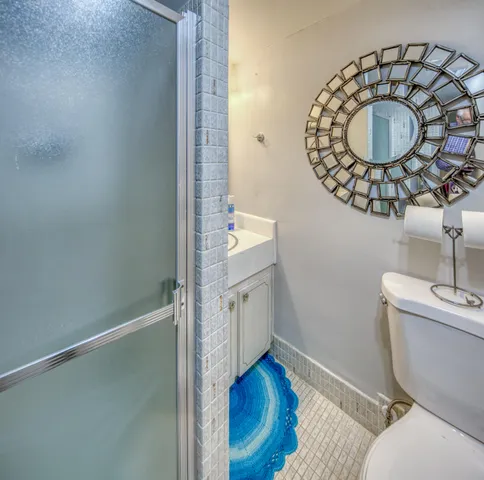 a bathroom with a toilet mirror vanity and a sink