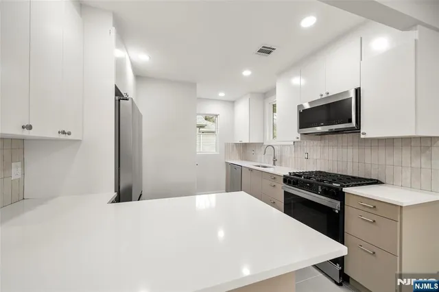 a kitchen with a sink a stove and cabinets
