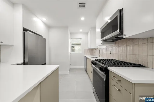 a kitchen with stainless steel appliances a sink stove and cabinets