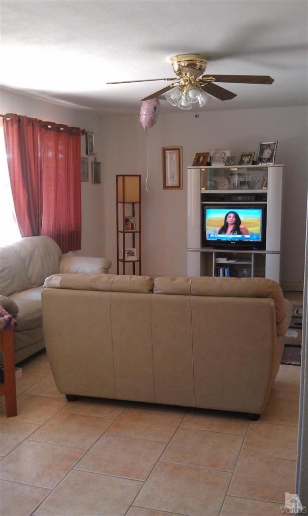 701 West Pleasant Valley Road Oxnard, CA 93033 - Photo 2 of 13 a living room with furniture a chandelier and a flat screen tv