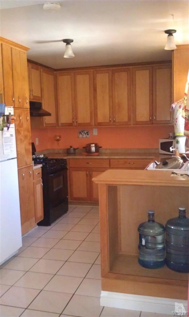 701 West Pleasant Valley Road Oxnard, CA 93033 - Photo 7 of 13 a kitchen with stainless steel appliances granite countertop a sink stove and cabinets