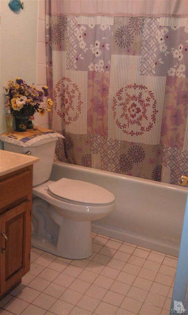 701 West Pleasant Valley Road Oxnard, CA 93033 - Photo 10 of 13 a white toilet sitting next to a bathroom sink and vanity