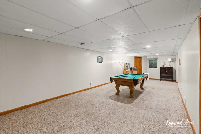 a room with furniture pool table and window