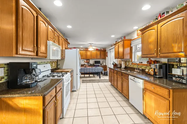 a kitchen with stainless steel appliances a stove top oven a sink a counter top space and cabinets