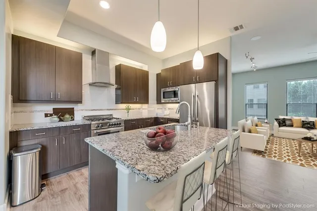 a kitchen with stainless steel appliances granite countertop a sink refrigerator and cabinets