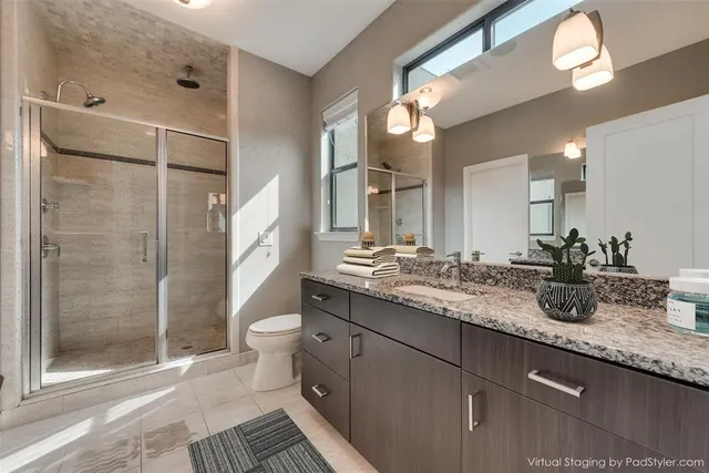 a bathroom with a granite countertop sink toilet and shower