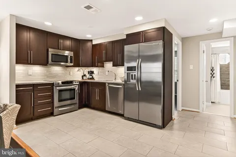 a kitchen with stainless steel appliances granite countertop a refrigerator and a stove top oven