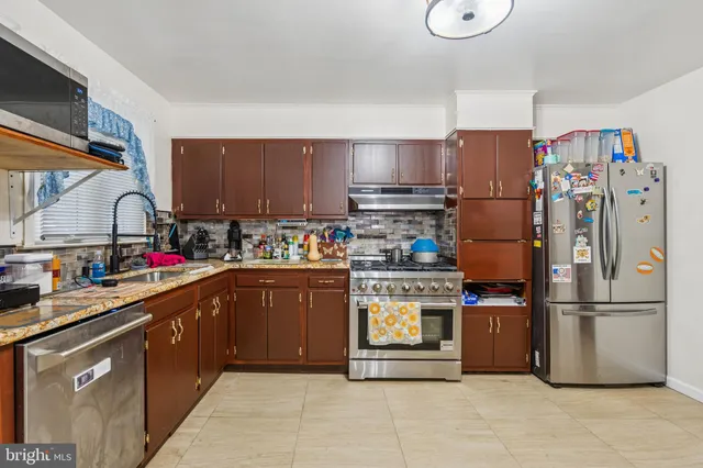 a kitchen with stainless steel appliances granite countertop a refrigerator a stove a sink and a refrigerator