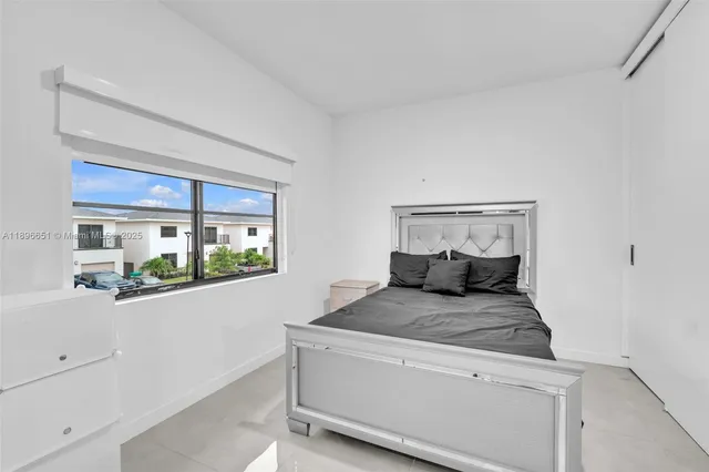 a large bed sitting in a bedroom next to a window