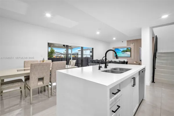 a kitchen with a sink white cabinets and appliances