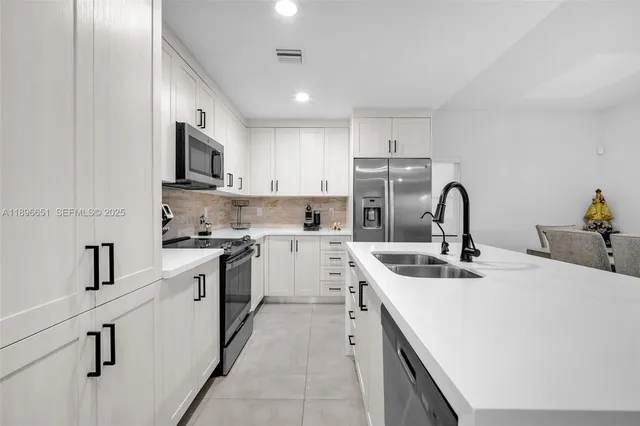 a kitchen with stainless steel appliances granite countertop a sink stove and microwave