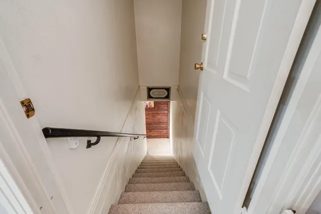 a living room with couches a fireplace and a chandelier