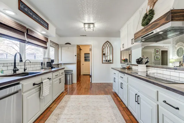 a kitchen with sink cabinets and wooden floor