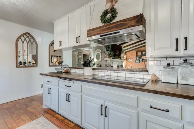 a kitchen with a refrigerator and wooden floor