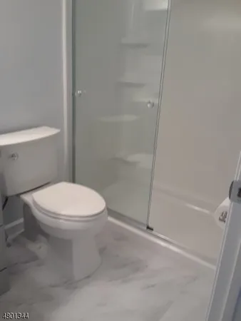 a white toilet sitting next to a bath tub and a shower