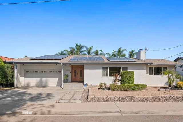 a view of a house with a yard and potted plants