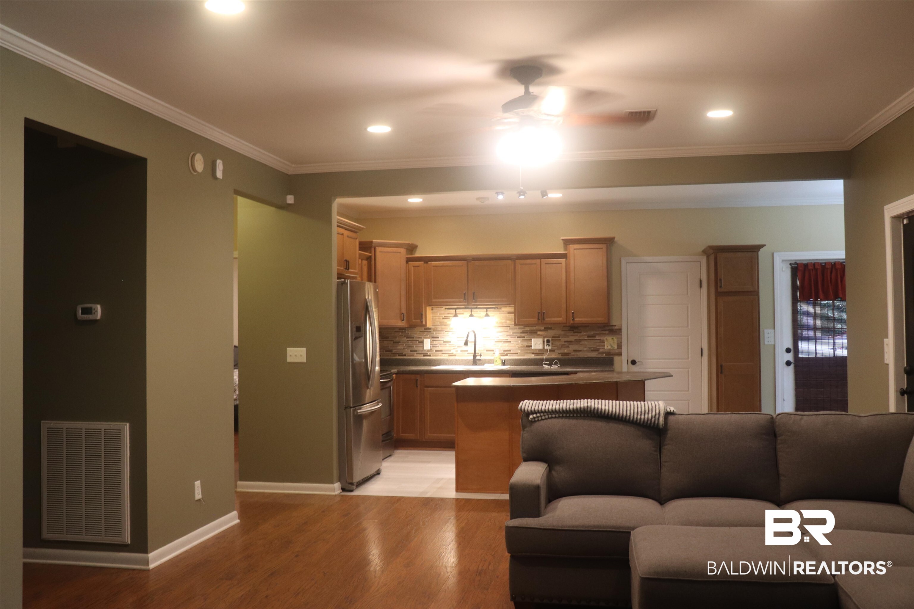 102 Brown Road Evergreen, AL 36401 - Photo 26 of 26 Kitchen featuring ceiling fan, open floor plan, crown molding, light wood finished floors, and freestanding refrigerator