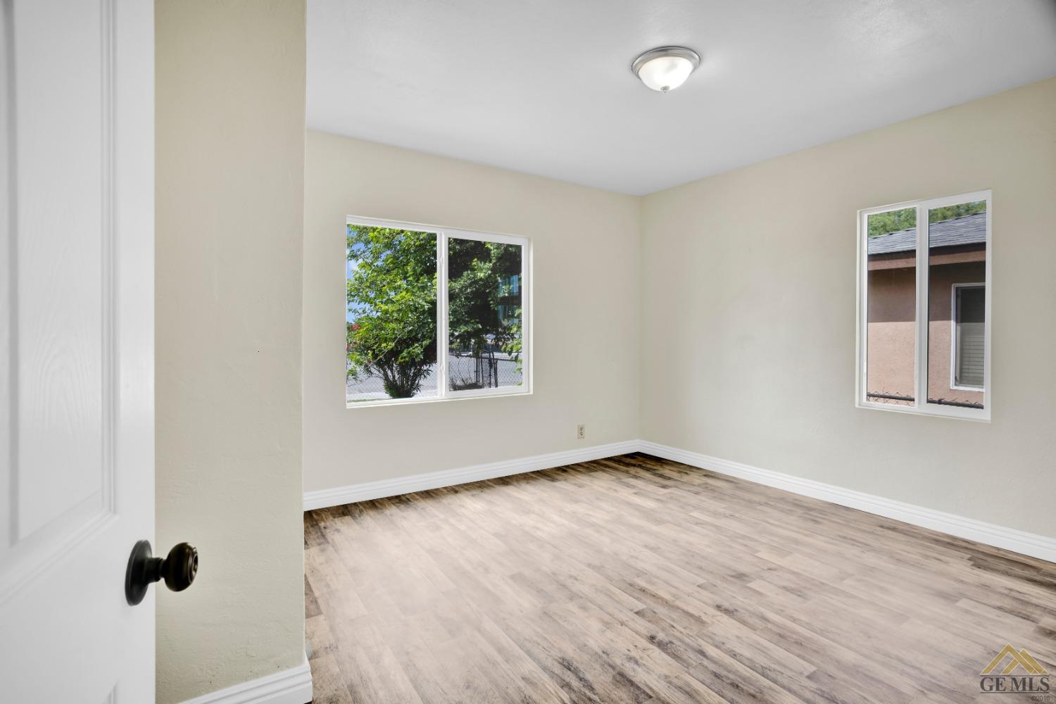 Undisclosed Address Bakersfield, CA 93308 - Photo 11 of 34 an empty room with wooden floor and windows