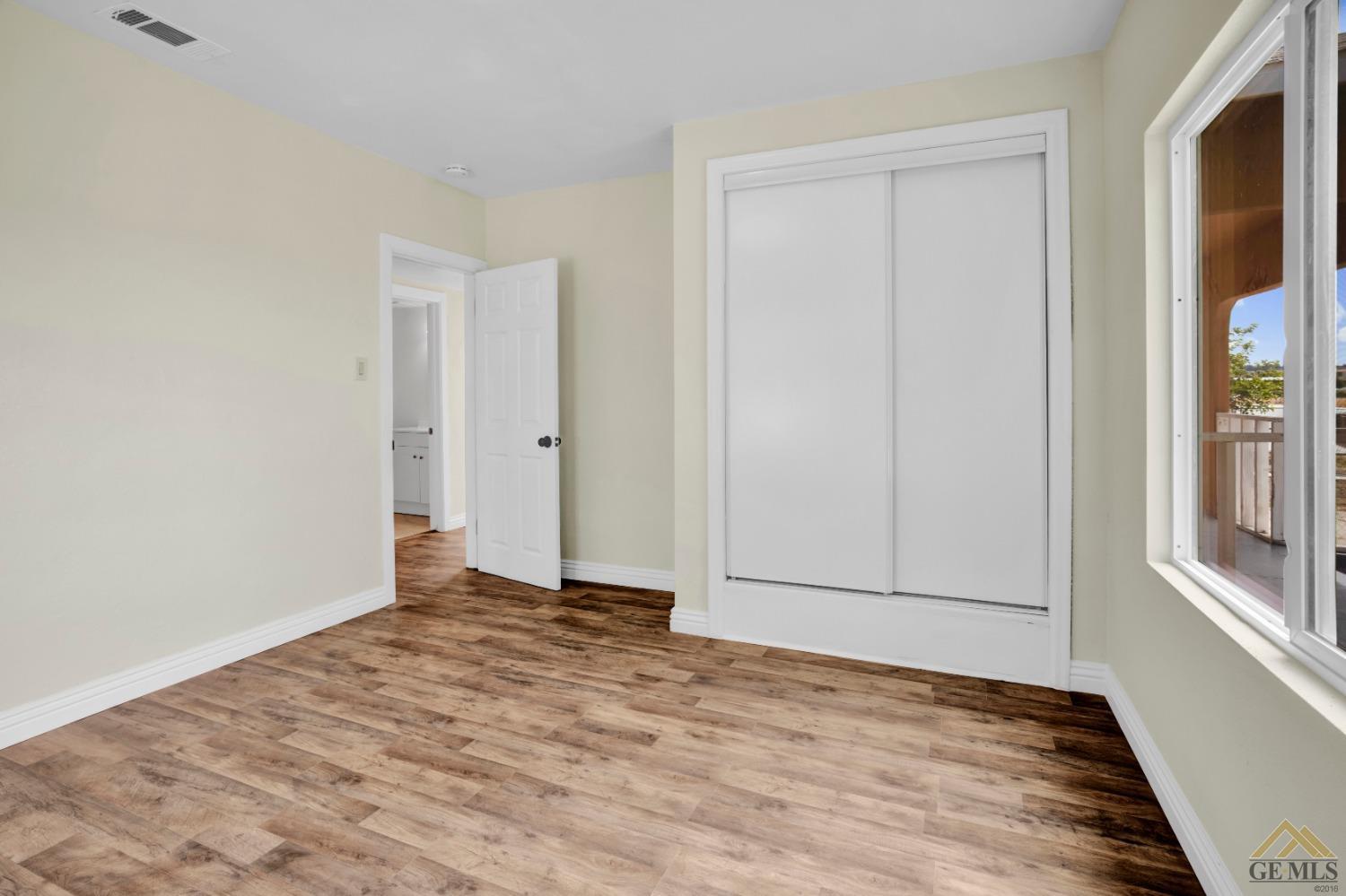 Undisclosed Address Bakersfield, CA 93308 - Photo 12 of 34 a view of an empty room with window and wooden floor