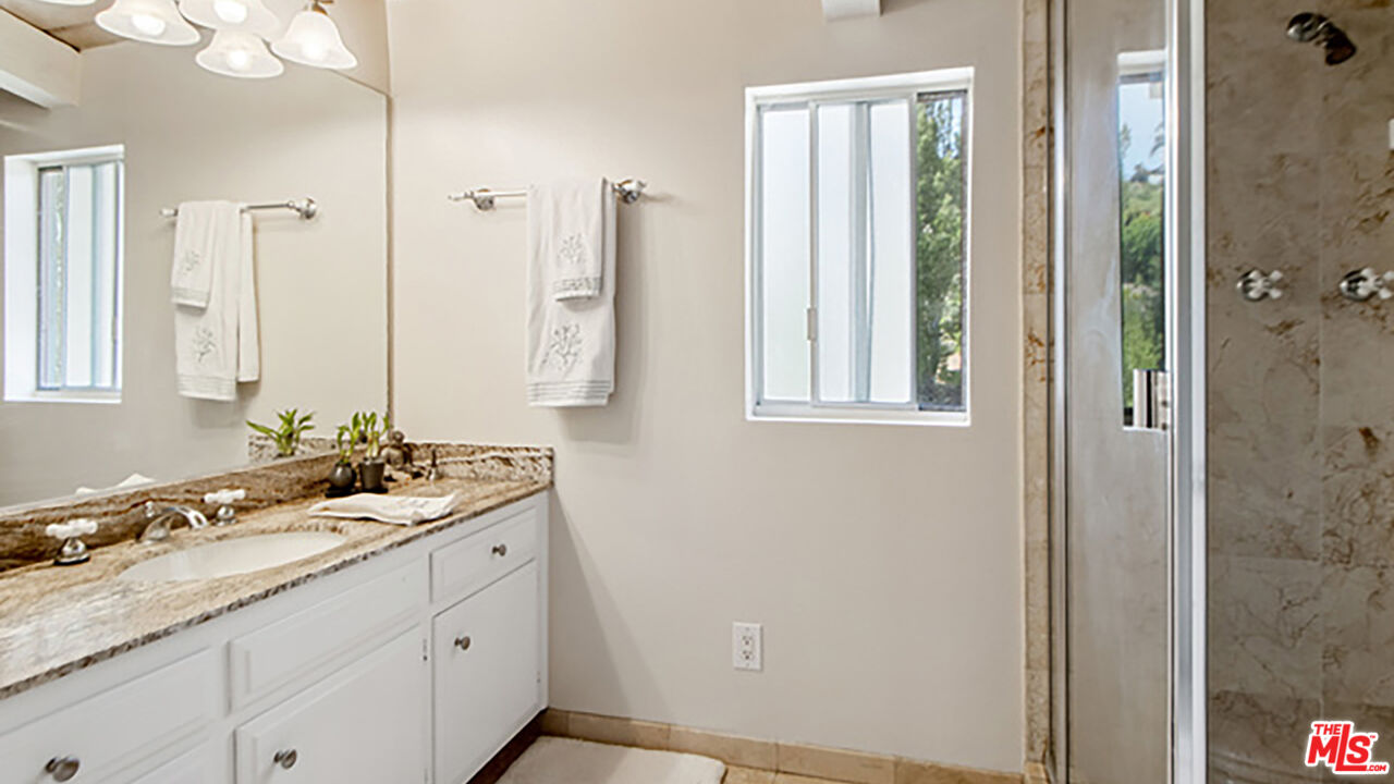 28286 Rey De Copas Lane Malibu, CA 90265 - Photo 16 of 26 a bathroom with a double vanity sink and a mirror