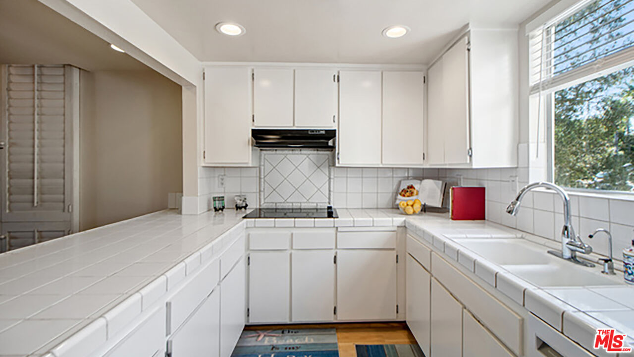 28286 Rey De Copas Lane Malibu, CA 90265 - Photo 6 of 26 a kitchen with a sink stove and cabinets