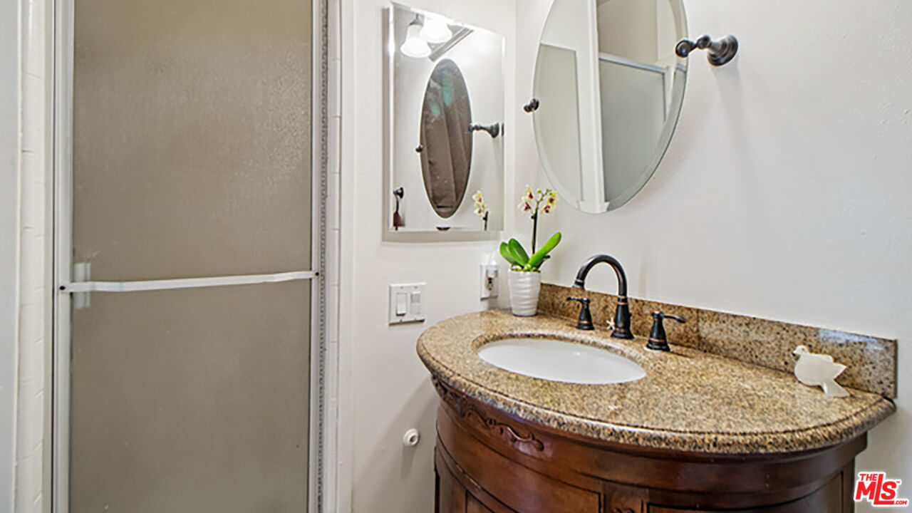 28286 Rey De Copas Lane Malibu, CA 90265 - Photo 10 of 26 a bathroom with a granite countertop sink and a mirror