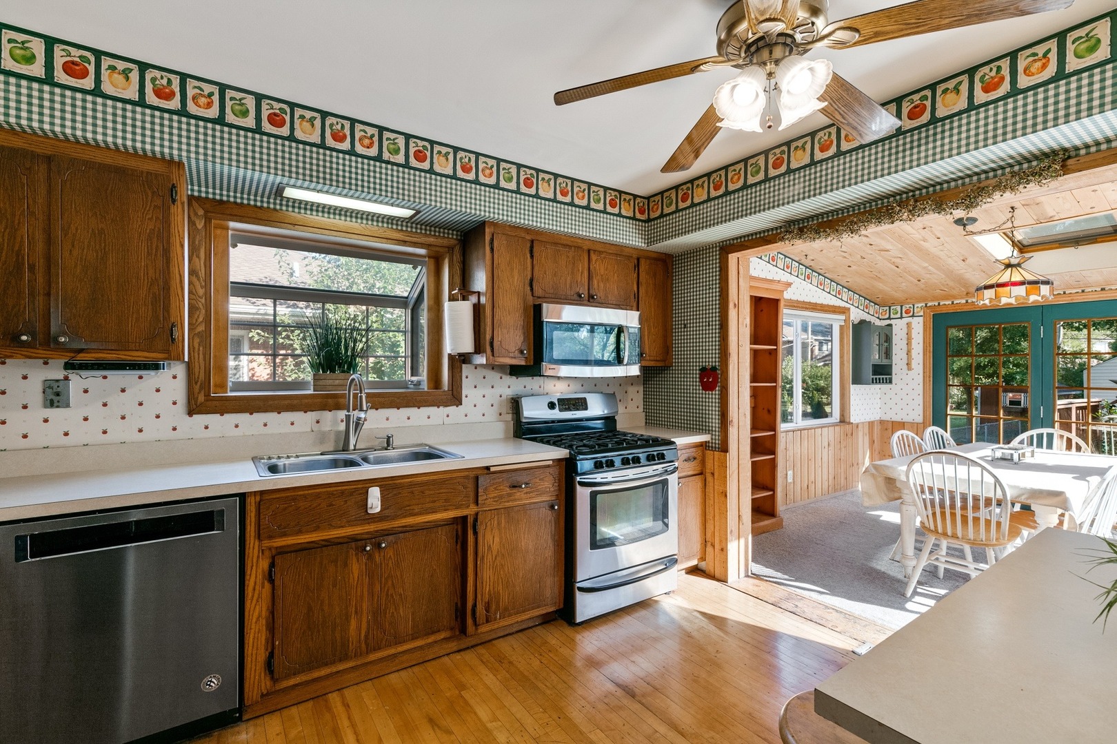 305 Olmsted Road Riverside, IL 60546 - Photo 8 of 33 a kitchen with stainless steel appliances granite countertop a stove top oven a sink dishwasher a dining table and chairs with wooden floor