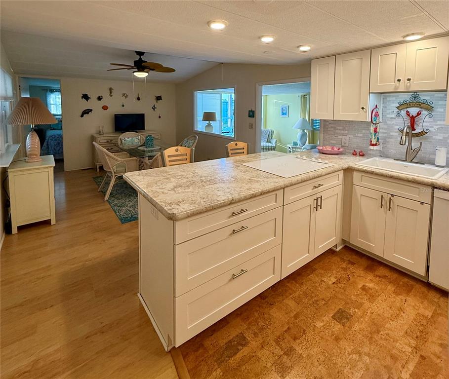6091 Peony Road Venice, FL 34293 - Photo 3 of 12 a kitchen with kitchen island granite countertop a sink cabinets and wooden floor
