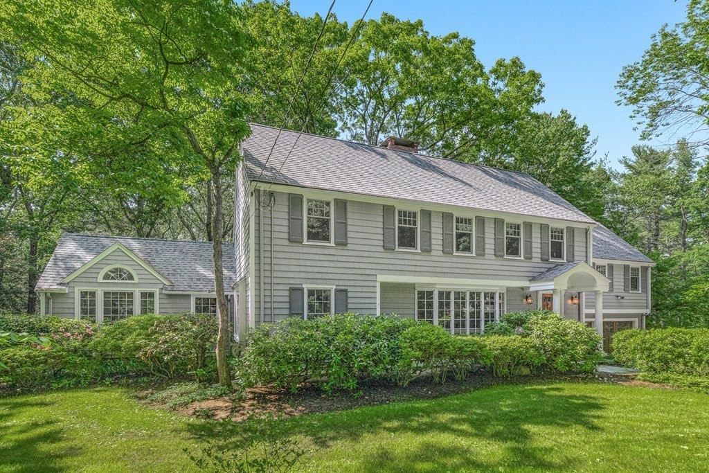 a front view of a house with a yard and trees