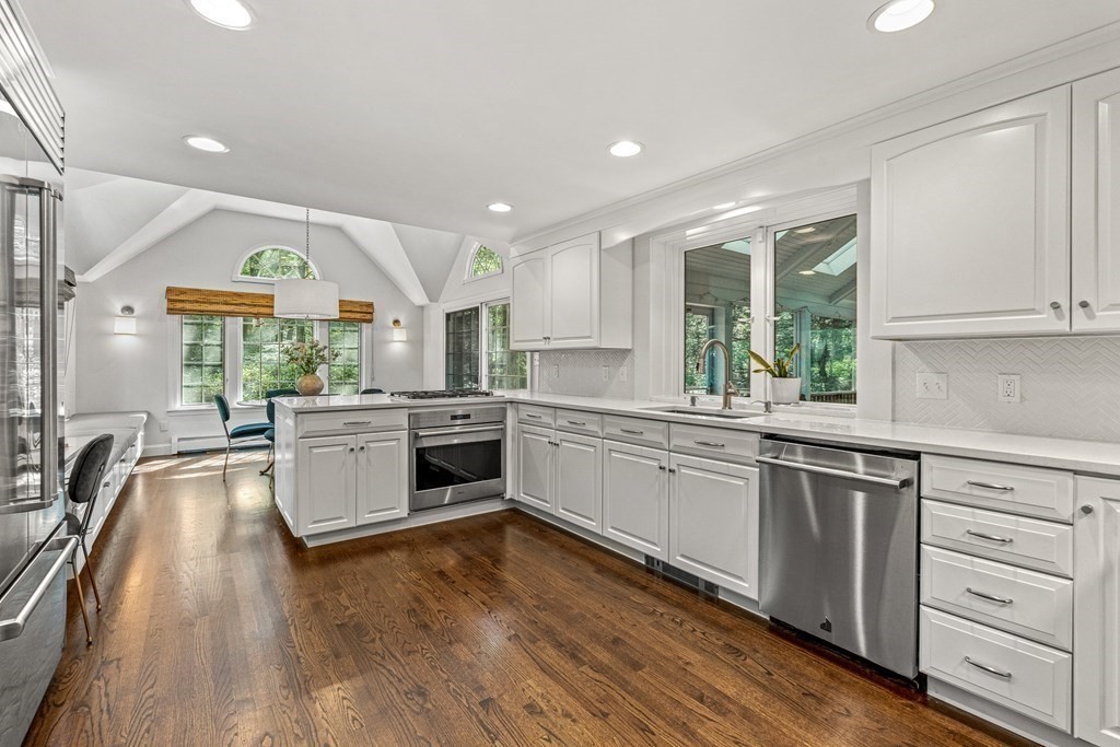 255 Westerly Road Weston, MA 02493 - Photo 9 of 35 a kitchen with a stove a sink and white cabinets with wooden floor