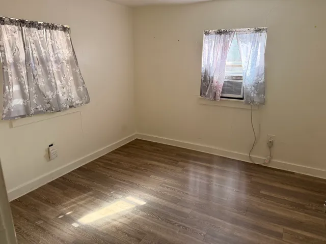 a view of a room with wooden floor and windows