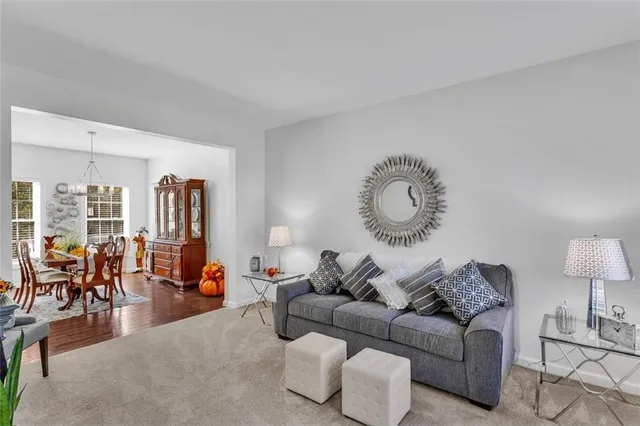 a living room with furniture a rug potted plant and a large window