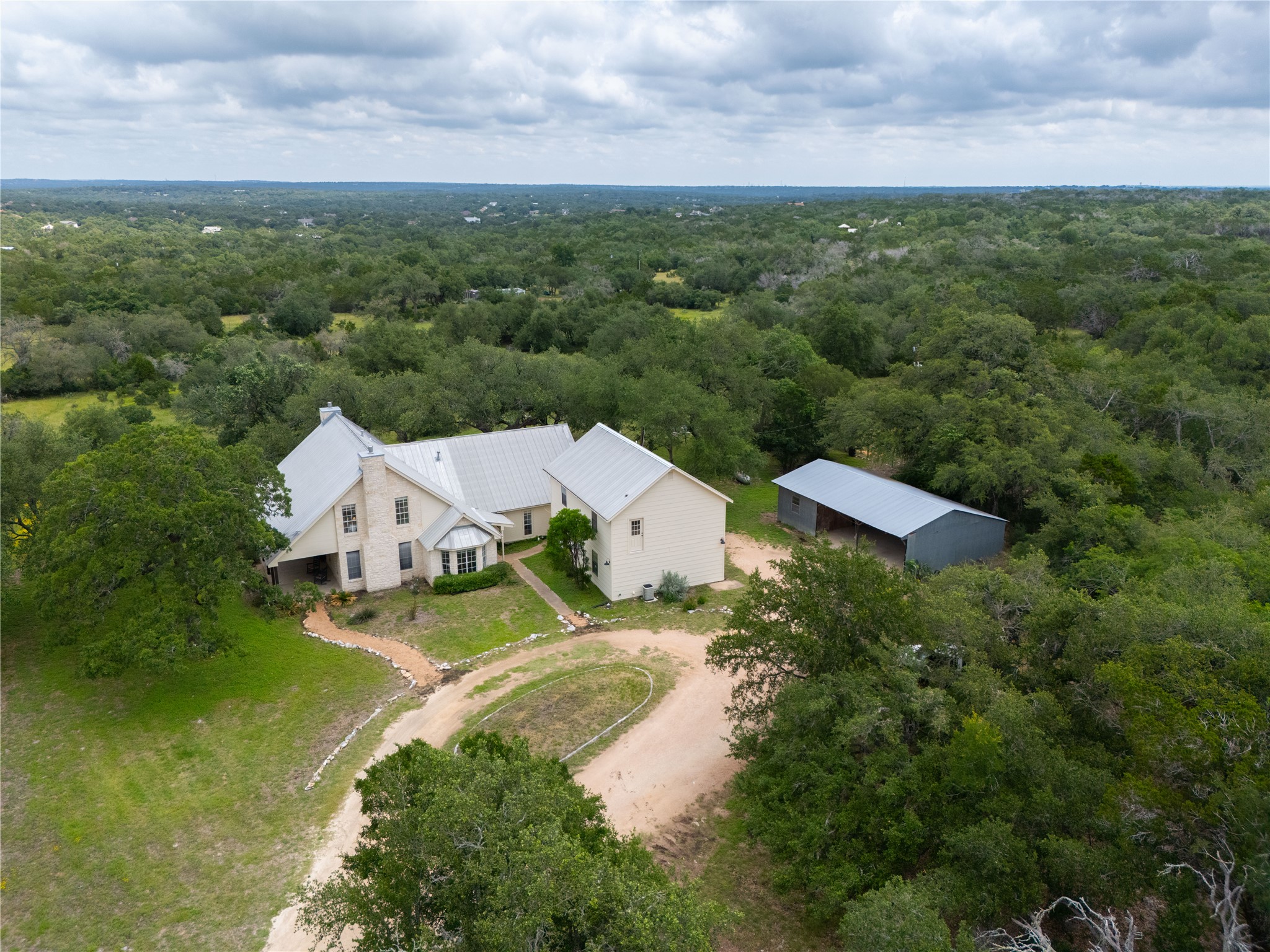 364 Nameless Road Driftwood, TX 78619 - Photo 1 of 32 This aerial view of 364 Nameless Rd. shows the circular driveway and the pastures in the backdrop.