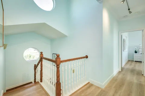 a view of a hallway with wooden floor and a chandelier