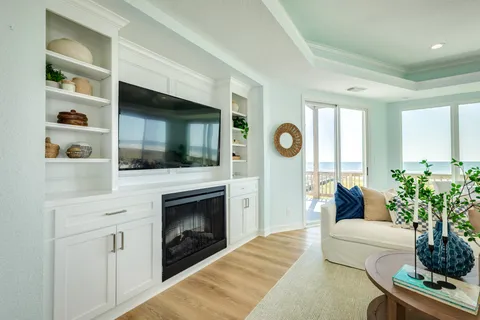 a living room with furniture a flat screen tv and a fireplace
