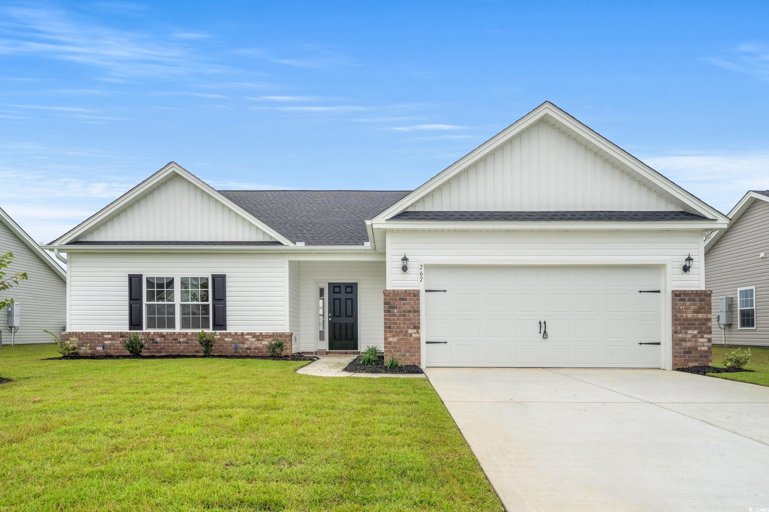 View of front of home featuring brick siding, board and batten siding, roof with shingles, and a garage