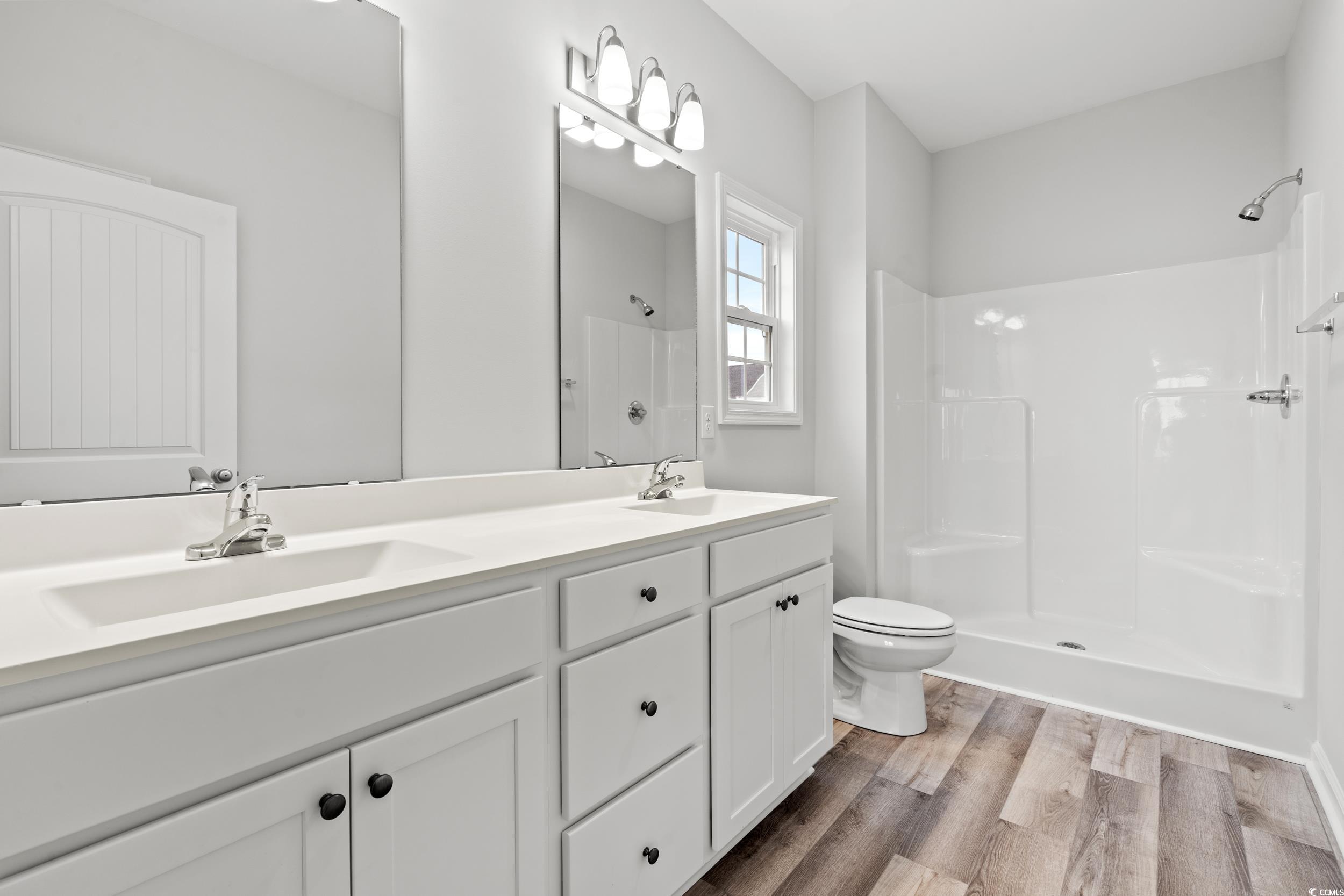 267 Stillbrook Drive Longs, SC 29568 - Photo 19 of 37 Bathroom featuring a stall shower, double vanity, and light wood-type flooring