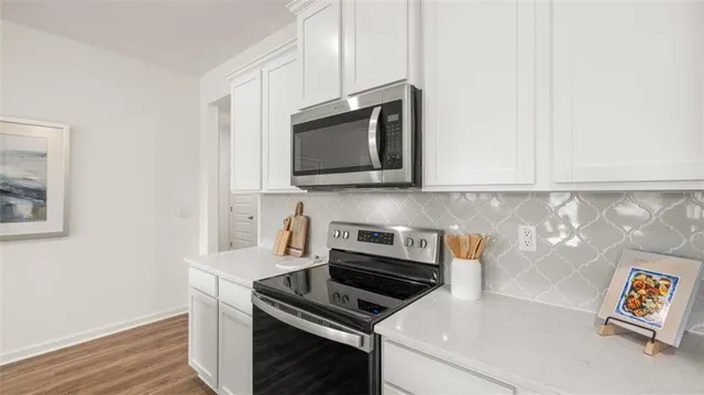 a kitchen with stainless steel appliances a sink a stove top oven a counter space and cabinets