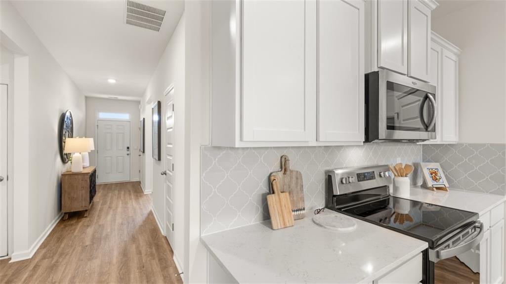 207 Cattle Drive Perry, GA 31069 - Photo 13 of 52 a kitchen with stainless steel appliances a sink a stove top oven a counter space and cabinets