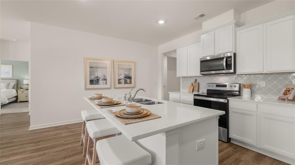 207 Cattle Drive Perry, GA 31069 - Photo 2 of 52 a kitchen with a stove a sink and a refrigerator