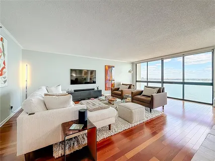 a view of empty room with wooden floor and floor to ceiling window