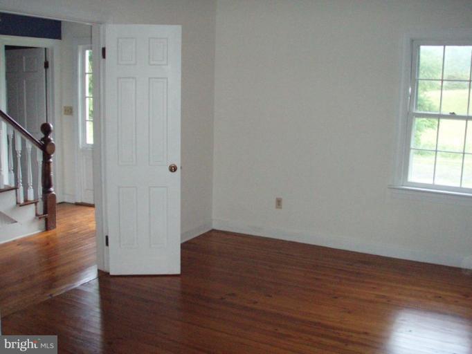 487 Rudasill Mill Road Woodville, VA 22749 - Photo 21 of 30 a view of an empty room with wooden floor and a window