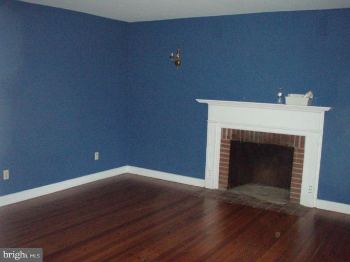 487 Rudasill Mill Road Woodville, VA 22749 - Photo 23 of 30 a view of empty room with wooden floor and fireplace