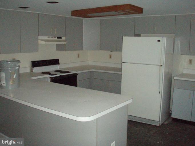 487 Rudasill Mill Road Woodville, VA 22749 - Photo 25 of 30 a kitchen with a refrigerator and white cabinets