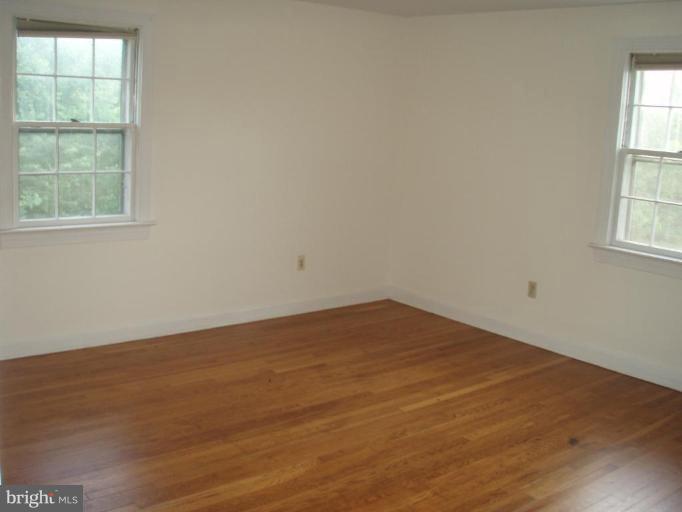 487 Rudasill Mill Road Woodville, VA 22749 - Photo 29 of 30 an empty room with wooden floor and windows