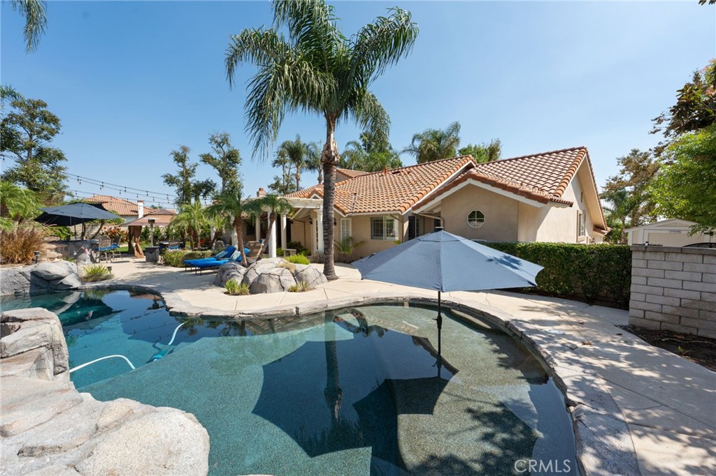 10588 Silver Spur Court Rancho Cucamonga, CA 91737 - Photo 54 of 63 a view of a patio with table and chairs potted plants and palm tree