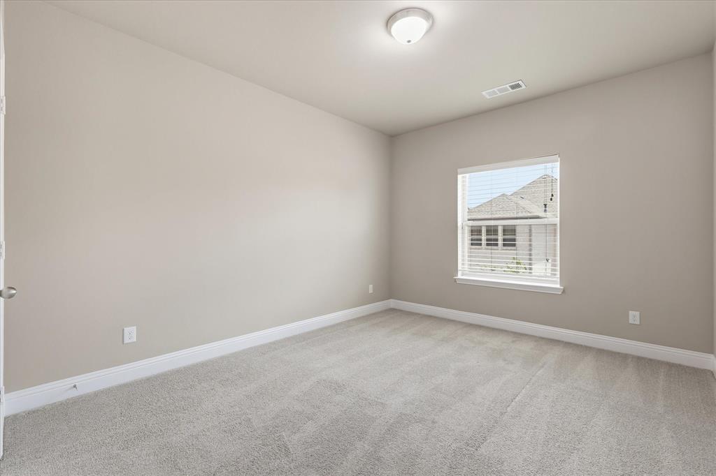 768 Huntingdon Street Coppell, TX 75019 - Photo 26 of 37 Comfortable secondary bedroom with neutral paint, carpet, white trim, and a bright window overlooking the neighborhood.