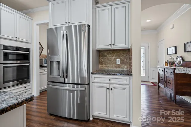 a kitchen with stainless steel appliances granite countertop a refrigerator and a stove top oven