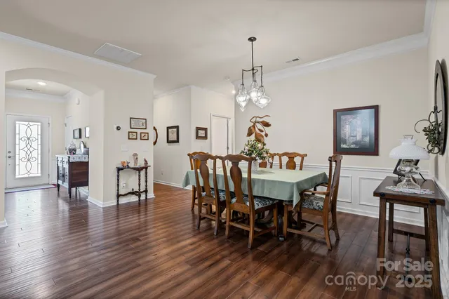 a view of a dining room with furniture wooden floor and chandelier