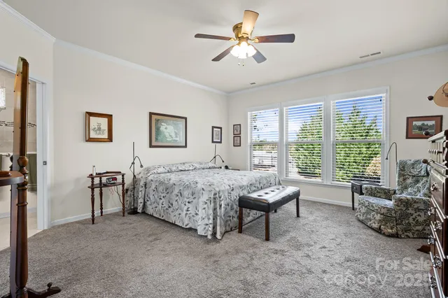 a bedroom with a bed furniture and a large window